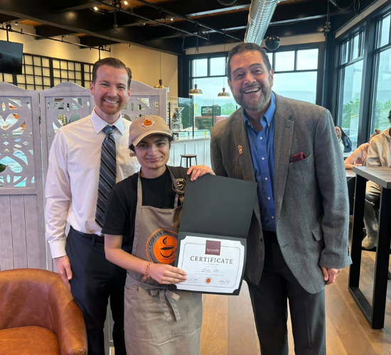 Coffee Inclusive badge recipient holding their certificate with Carl Sheperis and Anthony Melf