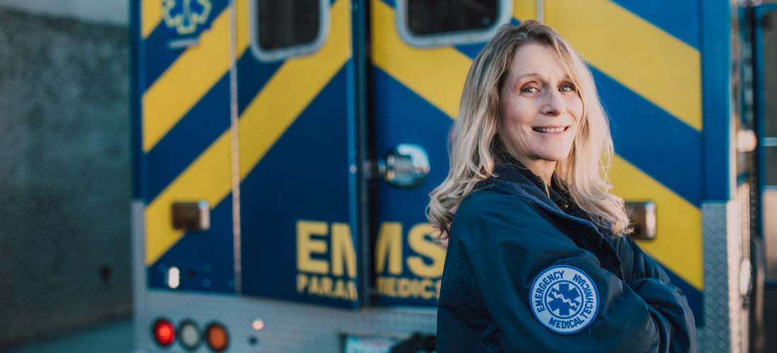 Female EMT standing in front of an ambulance