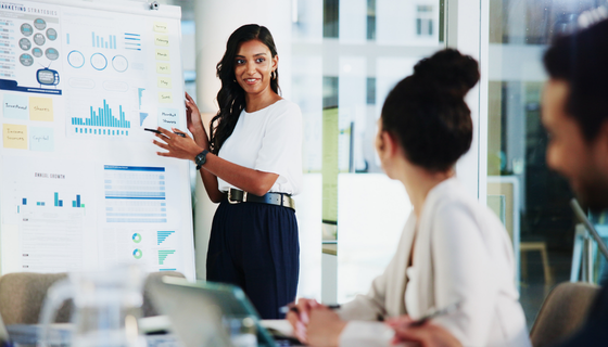 Woman presenting analytic data to group in office