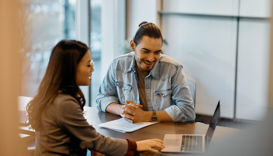 Man and woman sitting at table reviewing paperwork